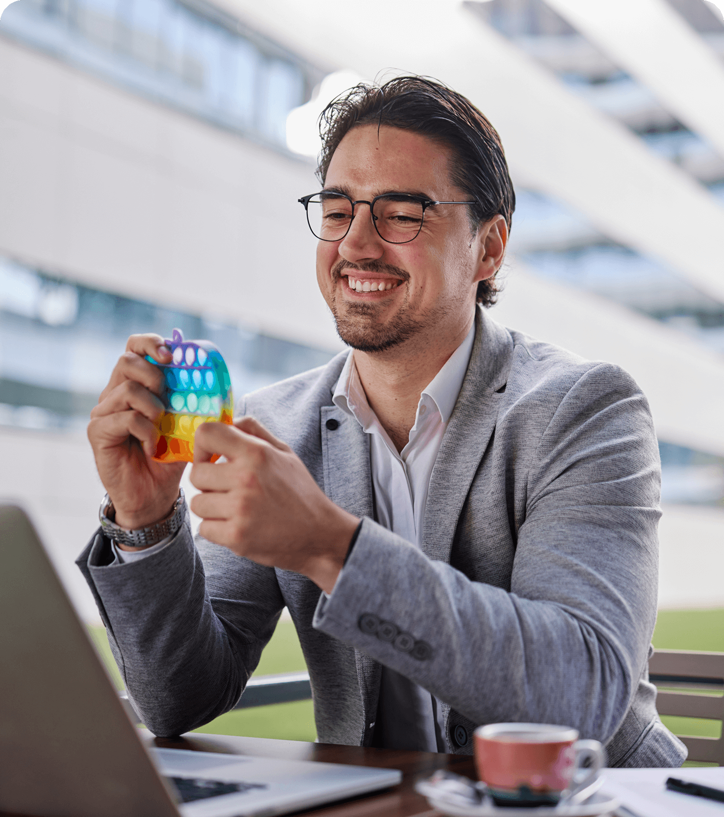 Man smiling with colorful stress toy.