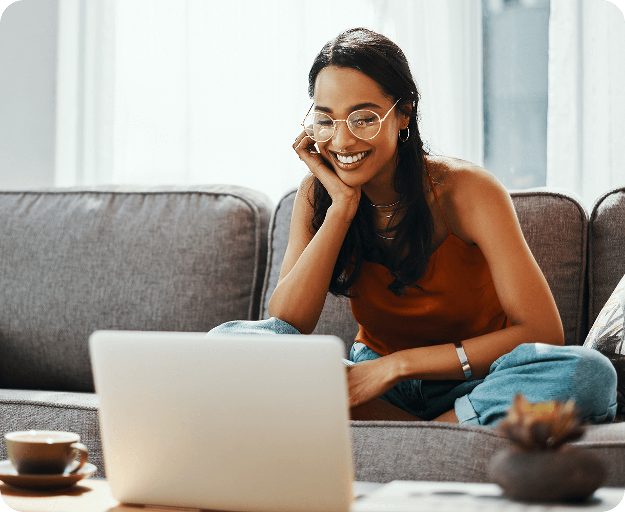 Woman smiling while using a laptop.